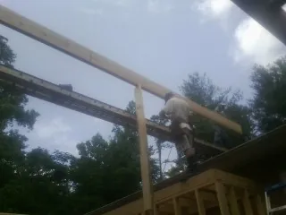 Carpenter setting a ridge beam over a new addition frame — Ice Dam Removal by Roofing Brothers in Lenexa