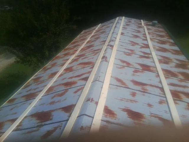 Rusted metal roof panels with new wood purlins before replacement — Storm Damage Roof Repair in Lenexa by Roofing Brothers