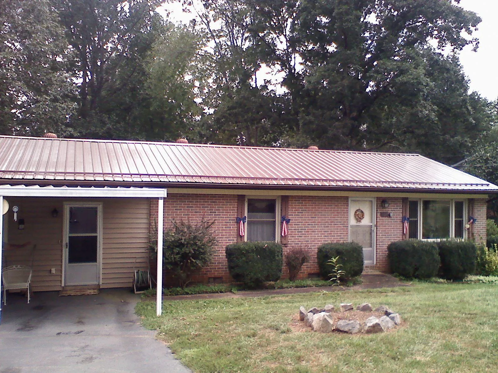 Bronze metal roof and carport on a brick ranch home — Roof Repair work by our crew in Lenexa