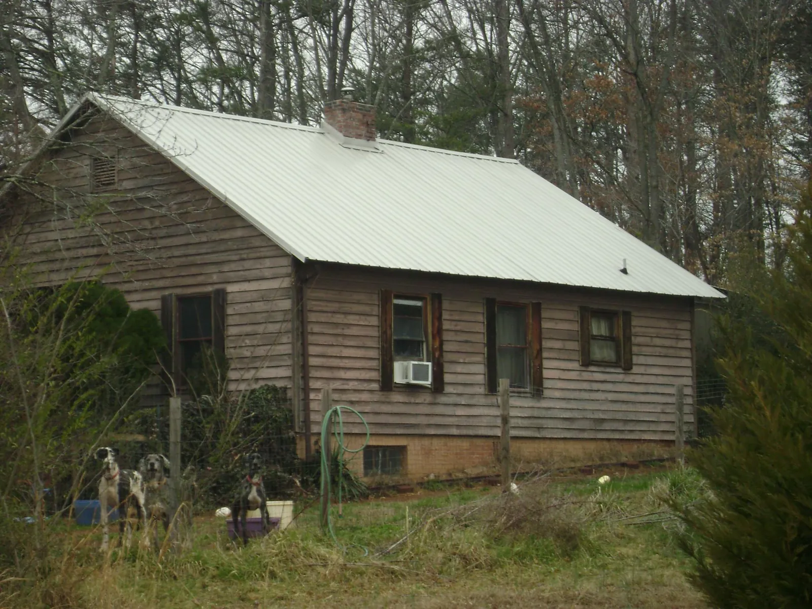 White metal roof on an old wood sided farmhouse, from a Metal Roof Installation job in Lenexa